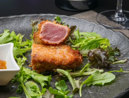 Lingotto di tonno con crema di zucca, misticanza, pomodoro secco e polvere di olive nere